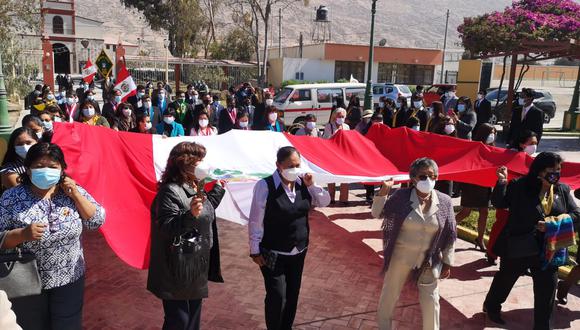 Pobladoras trasladan la bandera bicolor desde la parroquia San José hasta la plaza principal de Calana. (Foto: Difusión)