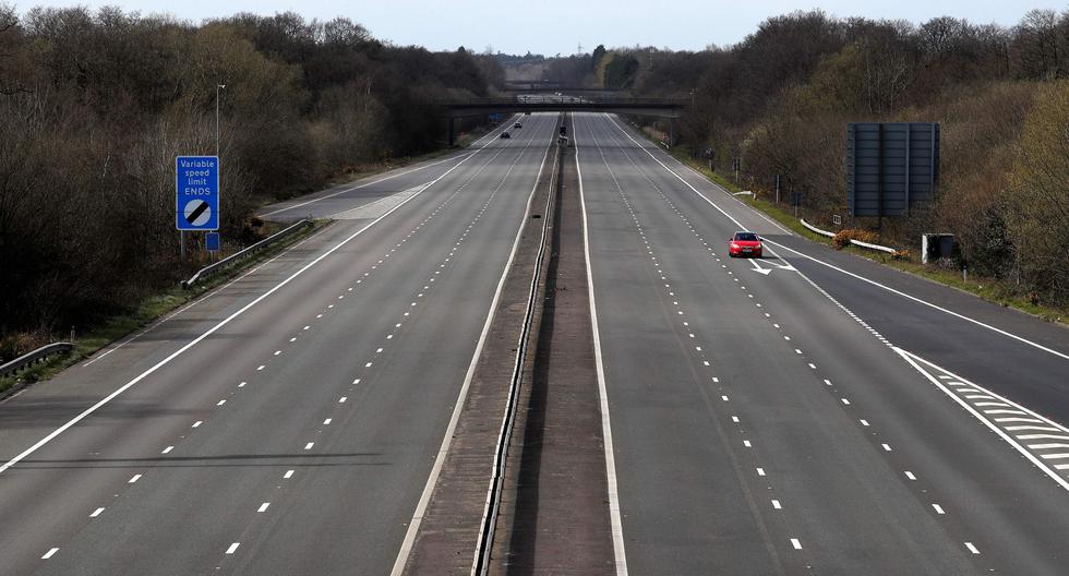 Un automóvil pasa por la autopista M3 casi desierta cerca de Fleet, al suroeste de Londres. El Reino Unido ha decretado confinamiento para frenar el brote de coronavirus. (AFP / Adrian DENNIS).