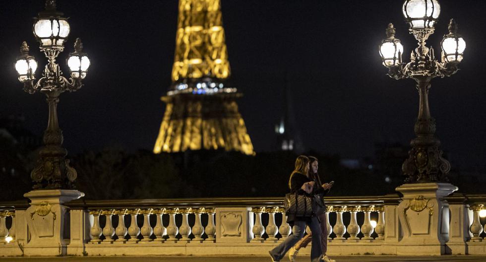 Imagen referencial. Dos peatones caminan por el puente Alexandre III poco antes del toque de queda nocturno por coronavirus en París (Francia), el 23 de octubre de 2020. (EFE/EPA/IAN LANGSDON).