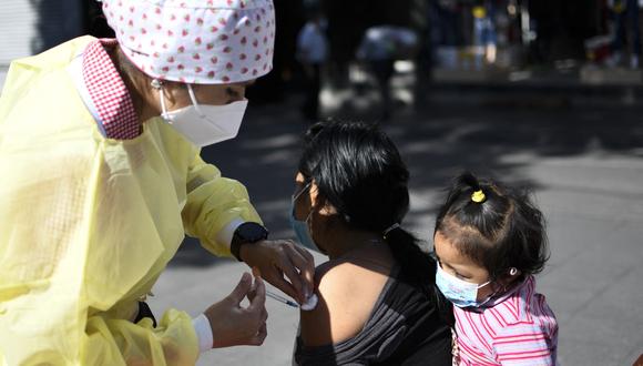 Una mujer recibe una dosis de la vacuna Pfizer-BioNTech contra el COVID-19, en un centro de vacunación en el Paseo de la Sexta, en Ciudad de Guatemala, el 25 de febrero de 2022. (Foto de Johan ORDONEZ / AFP)