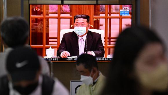 Las personas se sientan cerca de una pantalla que muestra una transmisión de noticias en una estación de tren en Seúl el 12 de mayo de 2022, del líder de Corea del Norte, Kim Jong Un, quitándose una máscara facial en la televisión para ordenar cierres en todo el país después de que el Norte confirmó su primer Covid- 19 casos. (Foto de Anthony WALLACE / AFP)