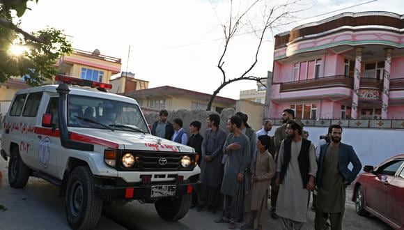 Los espectadores se paran junto a una ambulancia que transportaba víctimas cerca del lugar de una explosión en Kabul el 29 de abril de 2022. (Foto: Wakil kohsar / AFP)