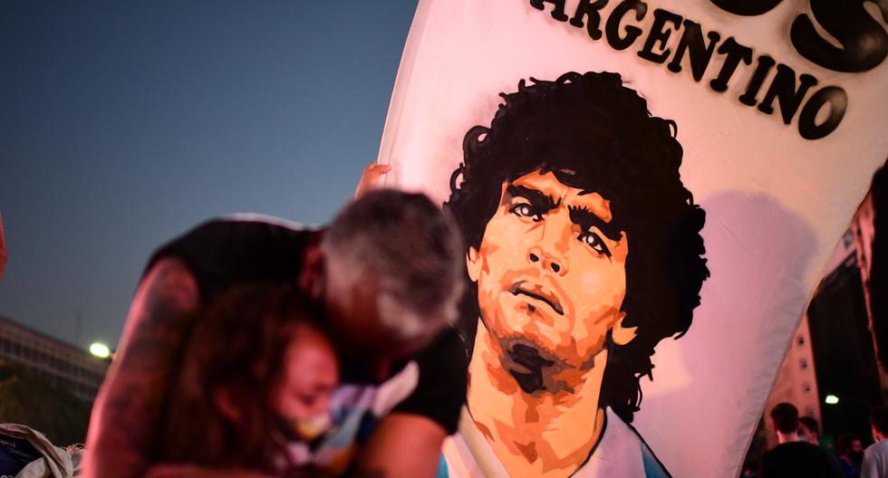 Imagen referencial. Un padre y su hija, fanáticos de la leyenda del fútbol argentino Diego Maradona, lloran mientras se reúnen junto al Obelisco en Buenos Aires (Argentina). (Ronaldo Schemidt / AFP)