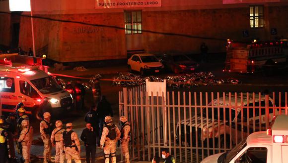 Bomberos y policías rescatan a migrantes de una estación migratoria en Ciudad Juárez, estado de Chihuahua, el 27 de marzo de 2023, donde al menos 39 personas murieron y decenas resultaron heridas tras un incendio en la estación migratoria. (Foto por HERIKA MARTÍNEZ / AFP)
