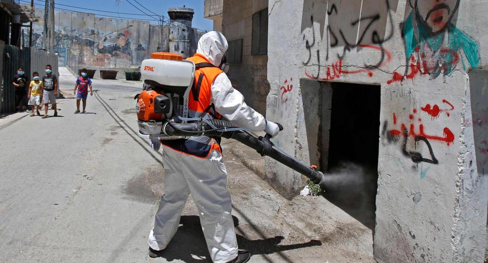 Imagen referencial. Un trabajador del municipio palestino de Belén desinfecta una calle por el coronavirus. (AFP / Musa Al SHAER).