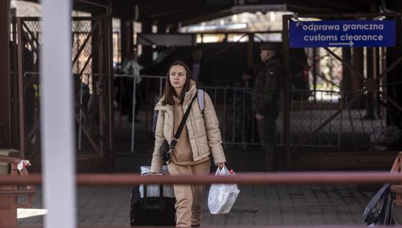 Una mujer joven es fotografiada mientras los refugiados de Ucrania desembarcan de un tren de Odessa y hacen fila para los controles de pasaporte a su llegada a la estación de tren en Przemysl, sureste de Polonia, el 6 de abril de 2022. (Foto de Wojtek RADWANSKI / AFP)