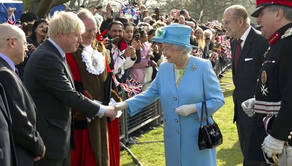 La reina Isabel II de Gran Bretaña le da la mano al entonces alcalde de Londres y posteriormente primer ministro, Boris Johnson, en 2012. (Foto: ARTHUR EDWARDS / POOL / AFP)