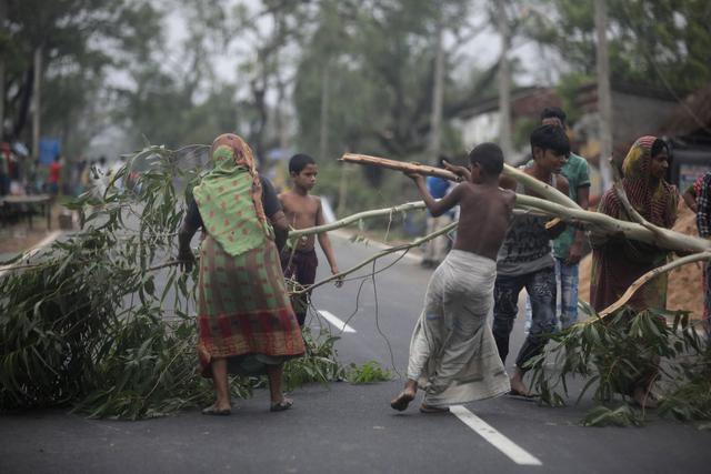 Los lugareños intentan quitar un árbol desarraigado de la carretera principal después de que el ciclón Amphan tocara tierra, en la aldea de Bokkhali cerca de la Bahía de Bengala, India, el 21 de mayo de 2020. El gobierno de Odisha y el gobierno de Bengala están considerando una evacuación masiva del área. (EFE / EPA / PIYAL ADHIKARY)