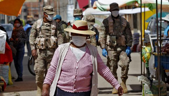 Los soldados patrullan mientras los residentes asisten a un mercado en Puno, Perú, cerca de la frontera con Bolivia, a pesar de la regulación para evitar eventos abarrotados para evitar la propagación del nuevo coronavirus (Foto: Juan Carlos CISNEROS / AFP)