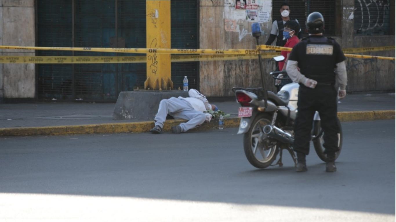 Un sereno observando a la persona echada al lado de un semáforo en La Victoria. Foto: Kelvin García