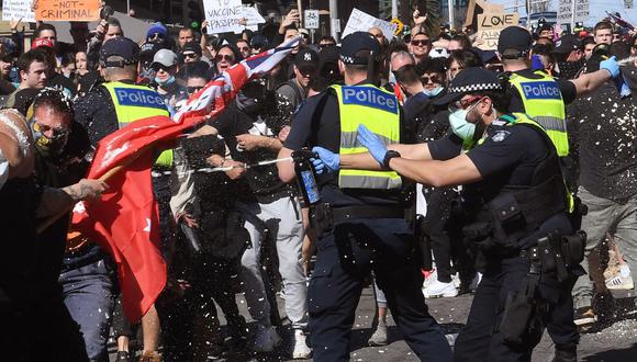 Manifestantes de la policía con gas pimienta durante un mitin anti-bloqueo en Melbourne (Australia), el 21 de agosto de 2021. (Foto de William WEST / AFP).