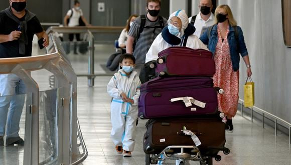 Viajeros internacionales que usan equipo de protección personal (PPE) llegan al aeropuerto Tullamarine de Melbourne. (Foto: William WEST / AFP)