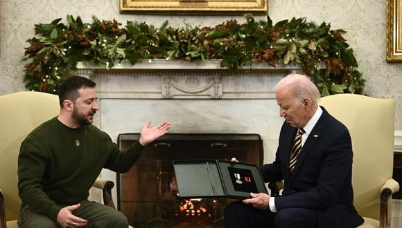 El presidente de Ucrania, Volodymyr Zelensky, entrega una medalla al presidente de los Estados Unidos, Joe Biden, en la Oficina Oval de la Casa Blanca, en Washington, DC, el 21 de diciembre de 2022. (Foto de Brendan SMIALOWSKI / AFP)