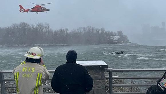 Un helicóptero de la Guardia Costera sobre un vehículo negro sumergido en el agua cerca del borde de las Cataratas del Niágara el 8 de diciembre de 2021. (Foto: New York State Office of Parks, Recreation and Historic Preservation / AFP)