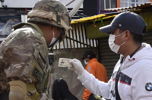 Un miembro de la policía militar verifica los documentos de identificación de las personas que pasan por las calles después de que la presidenta interina boliviana, Jeanine Anez, anunciara el cierre de las fronteras y la prohibición de cualquier movimiento dentro del país. (Foto: AFP)