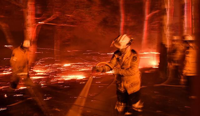 En vísperas al año nuevo, los bomberos manchan el área mientras luchan contra los incendios forestales alrededor de la ciudad de Nowra en el estado australiano de Nueva Gales del Sur el 31 de diciembre de 2019. (Foto: AFP)