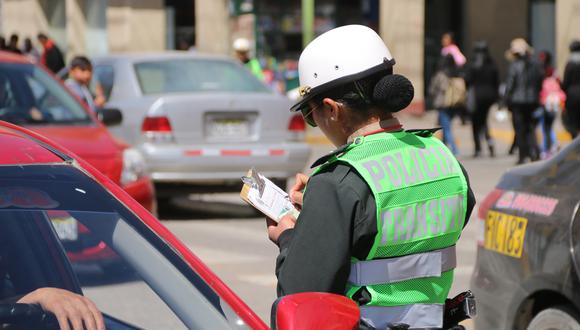 Policía de tránsito coloca papeleta a conductor en las calles de Huancayo.