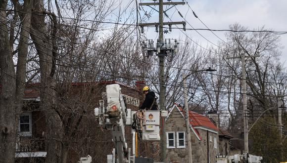 Los empleados de Hydro Quebec trabajan en las líneas eléctricas el 7 de abril de 2023 en Montreal, Canadá, después de que la lluvia helada azotara partes de Quebec y Ontario el 5 de abril. (Foto de ANDREJ IVANOV / AFP)