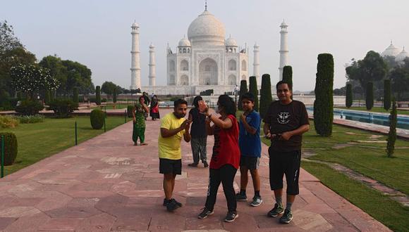 Los turistas toman fotografías mientras visitan el Taj Mahal en Agra el 21 de septiembre del 2020. El famoso Taj Mahal de la India y algunas escuelas reabrieron el 21 de septiembre cuando las autoridades siguieron adelante para impulsar la economía de la nación golpeada por el coronavirus, a pesar de las crecientes cifras de infecciones . (Foto: Sajjad Hussain / AFP)