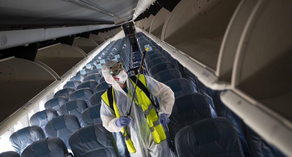 Imagen referencial. Un empleado, que usa equipo de protección, realiza una desinfección dentro de un avión de Air Europa en el aeropuerto de Son Sant Joan en Palma de Mallorca. (JAIME REINA / AFP).