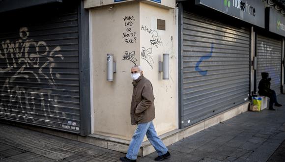 Un peatón con máscara facial como protección contra el Covid-19 camina en el centro de Atenas, Grecia. (Foto: Angelos Tzortzinis / AFP)