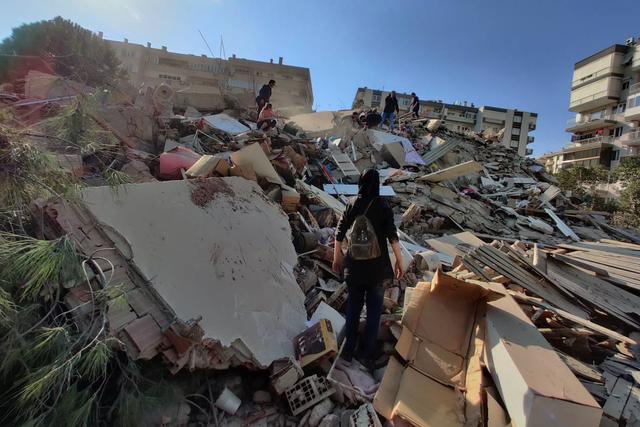 Personas son vistas en un edificio derrumbado tras un terremoto de magnitud 7,0 en el mar Egeo en Esmirna, Turquía. (EFE/EPA/Mehmet Emin Menguarslan).