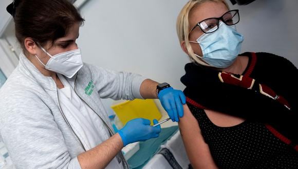 Un trabajador de la salud administra una dosis de la vacuna Covid-19 a una mujer, durante una campaña de vacunación. (Foto: JOSE JORDAN / AFP)