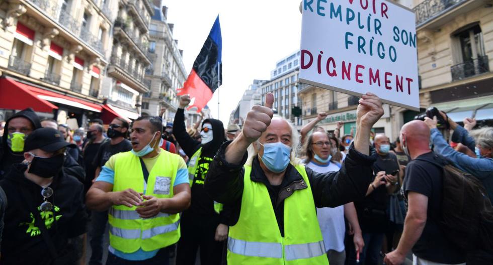 Un ciudadano sostiene un cartel que dice "Para poder llenar tu nevera con dignidad" durante una manifestación convocada por el movimiento de los chalecos amarillos en París, Francia. (AFP / Alain JOCARD).