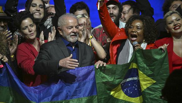 El expresidente brasileño (2003-2010) y candidato presidencial por el izquierdista Partido de los Trabajadores (PT) Luiz Inácio Lula da Silva sostiene una bandera brasileña durante una reunión con artistas e intelectuales en Sao Paulo, Brasil, el 26 de septiembre de 2022. - (Foto de NELSON ALMEIDA / AFP)