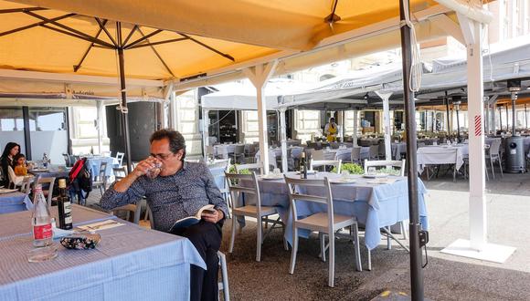 Los clientes se sientan en un restaurante después de reabrir en el paseo marítimo de Nápoles, Italia, el 26 de abril de 2021. (EFE / EPA / CESARE ABBATE)