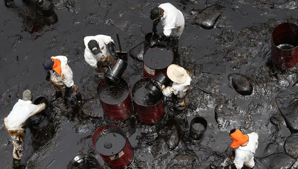 Personal contratado por Repsol intenta juntar a mano el petróleo acumulado en la playa Cavero de Ventanilla, una de las más afectadas. (Alessandro Currarino / @photo.gec)