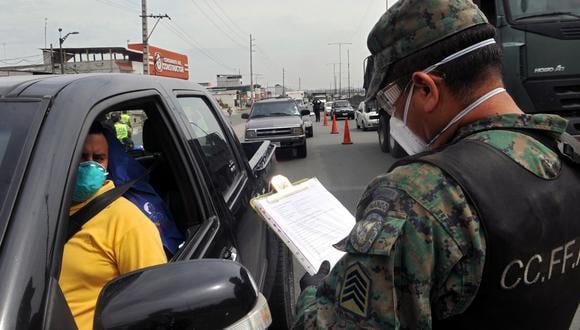 Oficiales de policía y soldados piden salvoconductos en un puesto de control en Nueva Prosperina en Guayaquil, Ecuador, durante la nueva pandemia de coronavirus. (Foto: AFP/JoséSánchez)