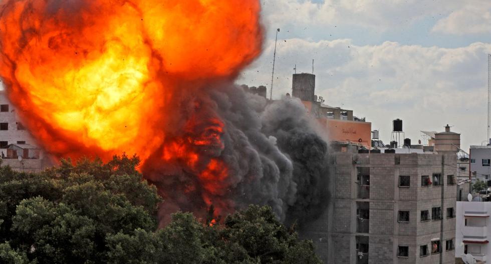 Una fotografía tomada el 13 de mayo de 2021 muestra una bola de fuego que envuelve el edificio de Al-Walid que fue destruido en un ataque aéreo israelí en la ciudad de Gaza. (Foto: AFP).