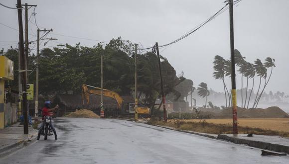 Un hombre toma fotografías mientras las palmeras se mueven con el viento en Nagua, República Dominicana, el 19 de septiembre de 2022, durante el paso del huracán Fiona. (Foto de Erika SANTELICES / AFP)