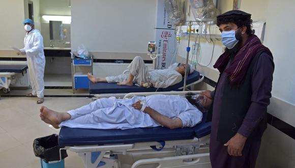 Un miembro de la familia se encuentra junto a un paciente con coronavirus en la unidad de cuidados intensivos (UCI) del hospital Muhammed Ali Jinnah en Kabul. (Wakil KOHSAR / AFP).