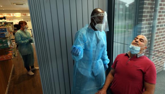 Un funcionario médico administra una prueba rápida de antígenos a un paciente en Pharmacy Servais en Jodoigne, a unos 45 kilómetros al sureste de Bruselas, el 12 de julio de 2021. (Foto: ERIC LALMAND / AFP)