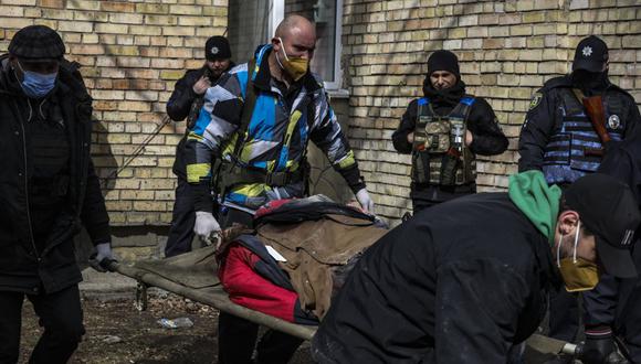 Un cuerpo es llevado a una escuela en Bucha, al noroeste de la capital ucraniana, Kiev, el 4 de abril de 2022. (Foto de RONALDO SCHEMIDT / AFP)