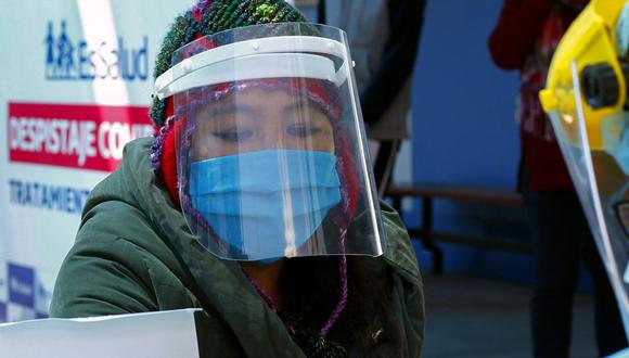 Gran cantidad de personas que resultaron afectadas por la pandemia está a la expectativa del cronograma del segundo bono. Aquí una ciudadana a quien le toman la temperatura (Foto: Carlos Mamani / AFP)