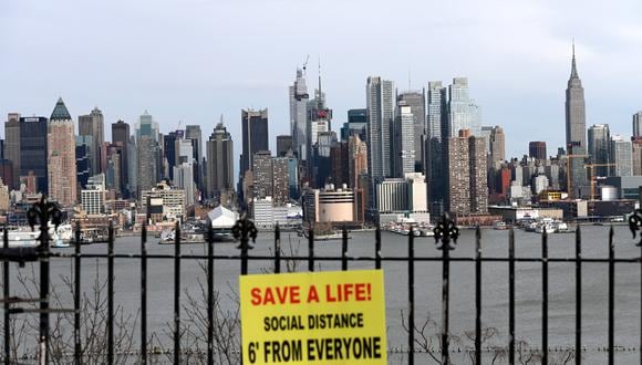 Un cartel cuelga en un parque con vistas al horizonte de Manhattan, en el que pide respetar la distancia social por el coronavirus. (Foto: AFP/Zinyange Auntony)