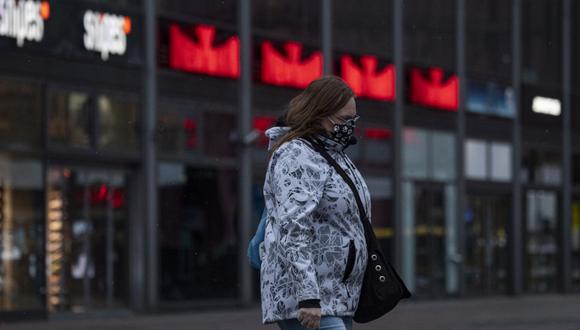 Una mujer con una mascarilla pasa frente a tiendas cerradas en el desértico distrito comercial Alexandeplatz, en Berlín, el pasado 7 de enero de 2021. (John MACDOUGALL / AFP)