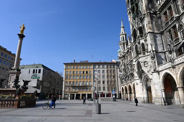 Solo unas pocas personas caminan el 20 de marzo de 2020 en la plaza Marienplatz en Munich, en el sur de Alemania, un punto de referencia de la ciudad, que normalmente está abarrotada pero permanece vacía debido a la nueva pandemia de coronavirus. (Foto: AFP)
