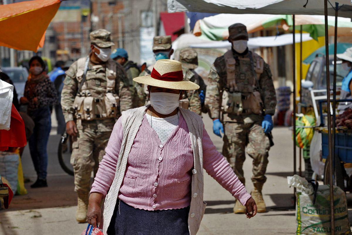 Los soldados patrullan mientras los residentes asisten a un mercado en Puno, Perú, cerca de la frontera con Bolivia, a pesar de la regulación para evitar eventos abarrotados para evitar la propagación del nuevo coronavirus (Foto: Juan Carlos CISNEROS / AFP)