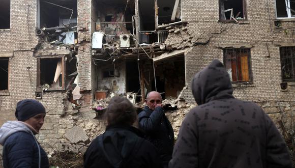 Residentes locales observan un edificio residencial destruido por un ataque con misiles en Konstantinovka, en la región oriental de Donetsk, el 14 de octubre de 2022. (Foto de Anatolii Stepanov / AFP)