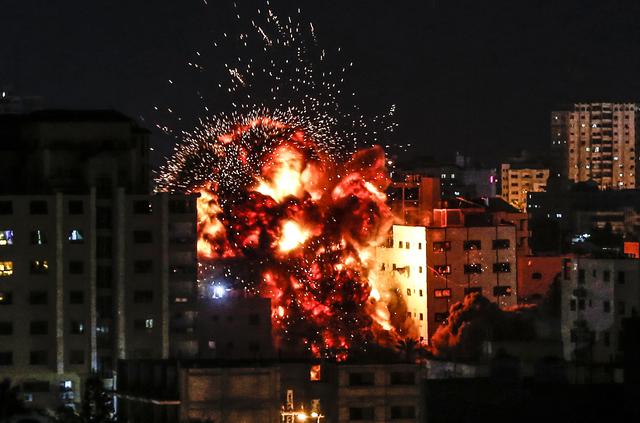 Una explosión entre los edificios durante un ataque aéreo israelí en la ciudad de Gaza el 4 de mayo de 2019. - Los militantes de Gaza dispararon una lluvia de cohetes contra Israel, que respondieron con ataques aéreos, dijeron las autoridades, mientras un frágil alto el fuego volvía a fallar. (Foto por Mahmud Hams / AFP)