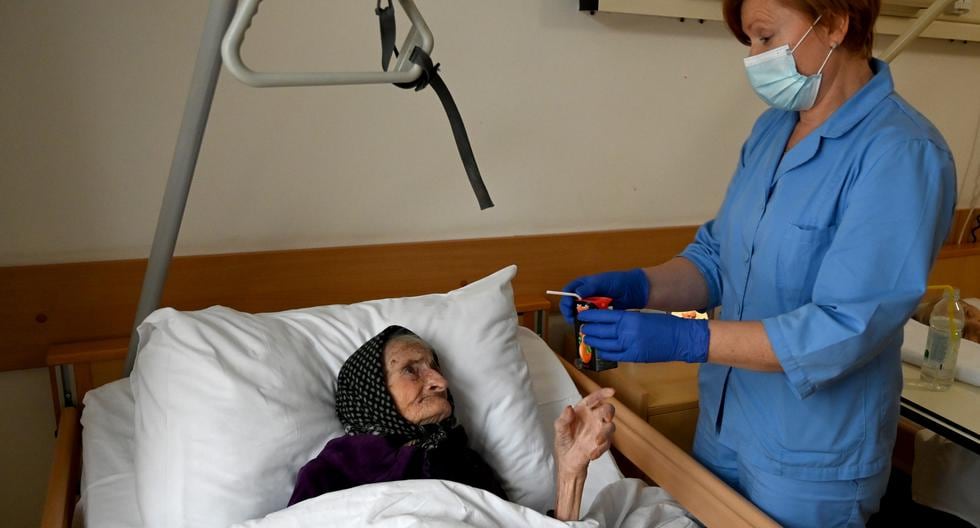 Una enfermera atiende a Margareta Kranjcec, de 99 años, que descansa en su cama en un hogar de ancianos en Karlovac, Croacia. (DENIS LOVROVIC / AFP).