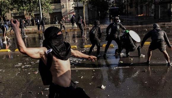 Manifestantes chocan con la policía antidisturbios durante una protesta contra el gobierno del presidente chileno Sebastián Piñera en Santiago. (AFP/Martin BERNETTI).