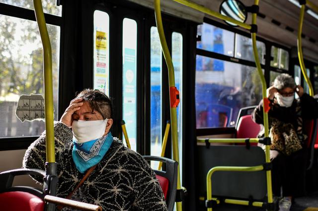 Pasajeros de un autobús en Buenos Aires usan mascarilla en medio de la pandemia del coronavirus. El estudio de "The Lancet" advierte que el uso de mascarillas y la distancia social siguen siendo necesarias durante un tiempo tras haber levantado un confinamiento. (Foto: Ronaldo Schemidt / AFP)