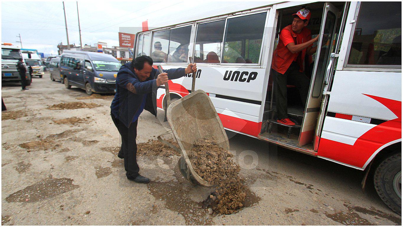 Por pésimo estado de vía, transportistas tapan con caliche los huecos de avenida (FOTOS)