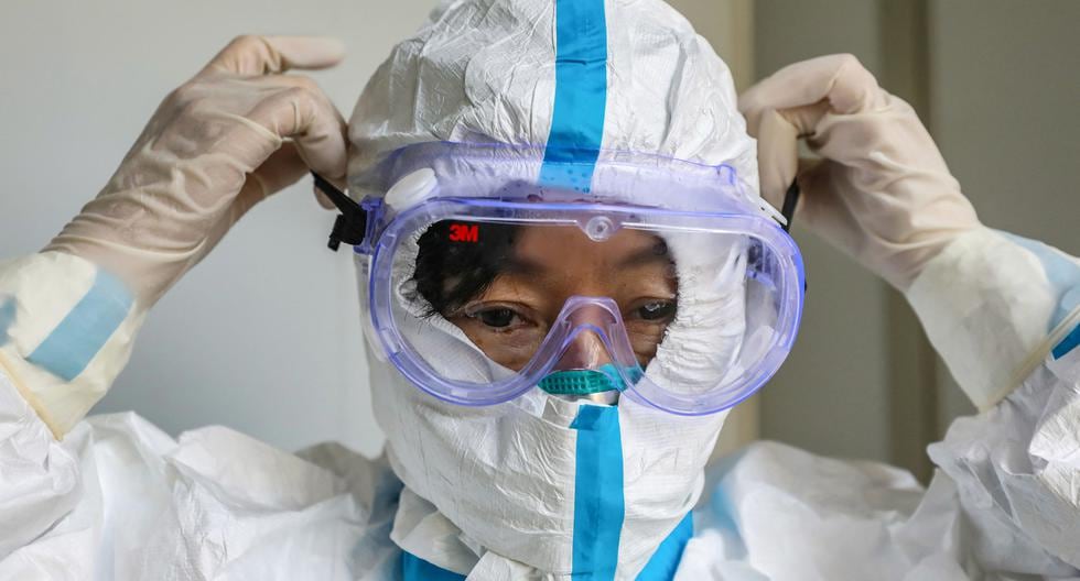 Un trabajador de salud se coloca un traje de seguridad en Wuhan, en enero de 2020. (Foto: STR / AFP)