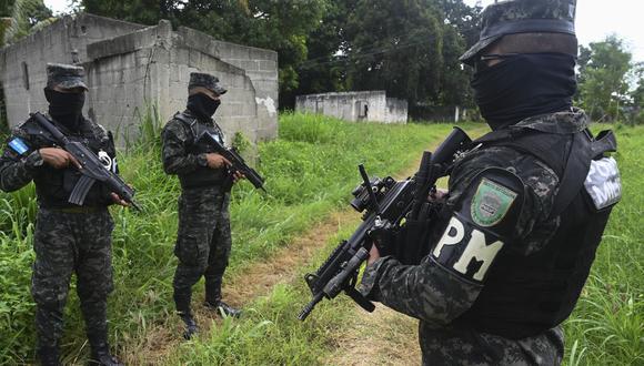Miembros de la Policía Militar de Orden Público (PMOP) caminan cerca de una casa abandonada en Chamelecon, en los suburbios de San Pedro Sula, Honduras, el 16 de julio de 2022. (Foto de Orlando SIERRA / AFP)